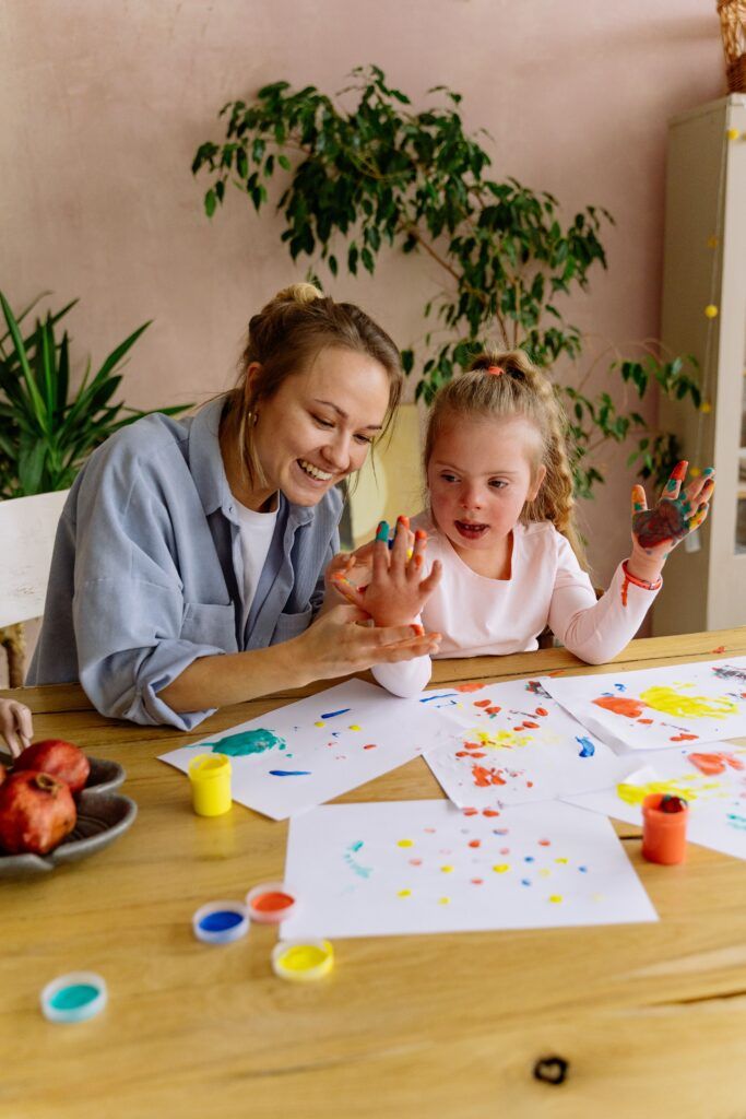 Parent and child engaging in playful painting activity during Parent-Child Interaction Therapy (PCIT) to strengthen connection and support healthy emotional development.
